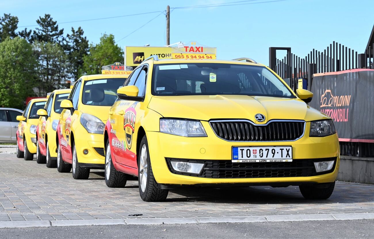 Red vozila Zrnce Taxi parkiranih ispred vozila kuće